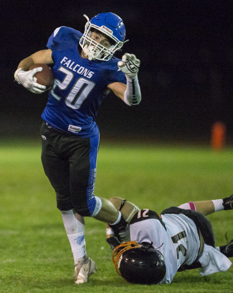 South Whidbey’s Erik Haugen escapes a tackle by Granite Falls’ Bradley Kehoe during the game on Friday, Oct. 29, 2021 in Langley, Wa. (Olivia Vanni / The Herald)
