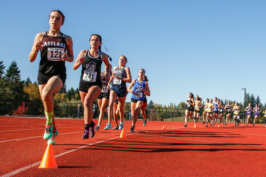 Kamiak’s Emma Arceo, second in image, finishes 12th Saturday afternoon during the 4A District 1 Cross Country Championships at Lakewood High School in Arlington on October 30, 2021. (Kevin Clark / The Herald)
