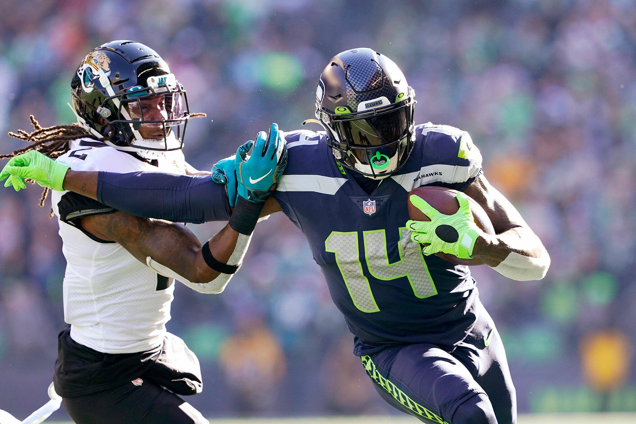 Seattle Seahawks wide receiver DK Metcalf (14) pushes off of Jacksonville Jaguars defensive back Rayshawn Jenkins as he runs with the ball during the first half of a game Sunday in Seattle. (AP Photo/Ted S. Warren)