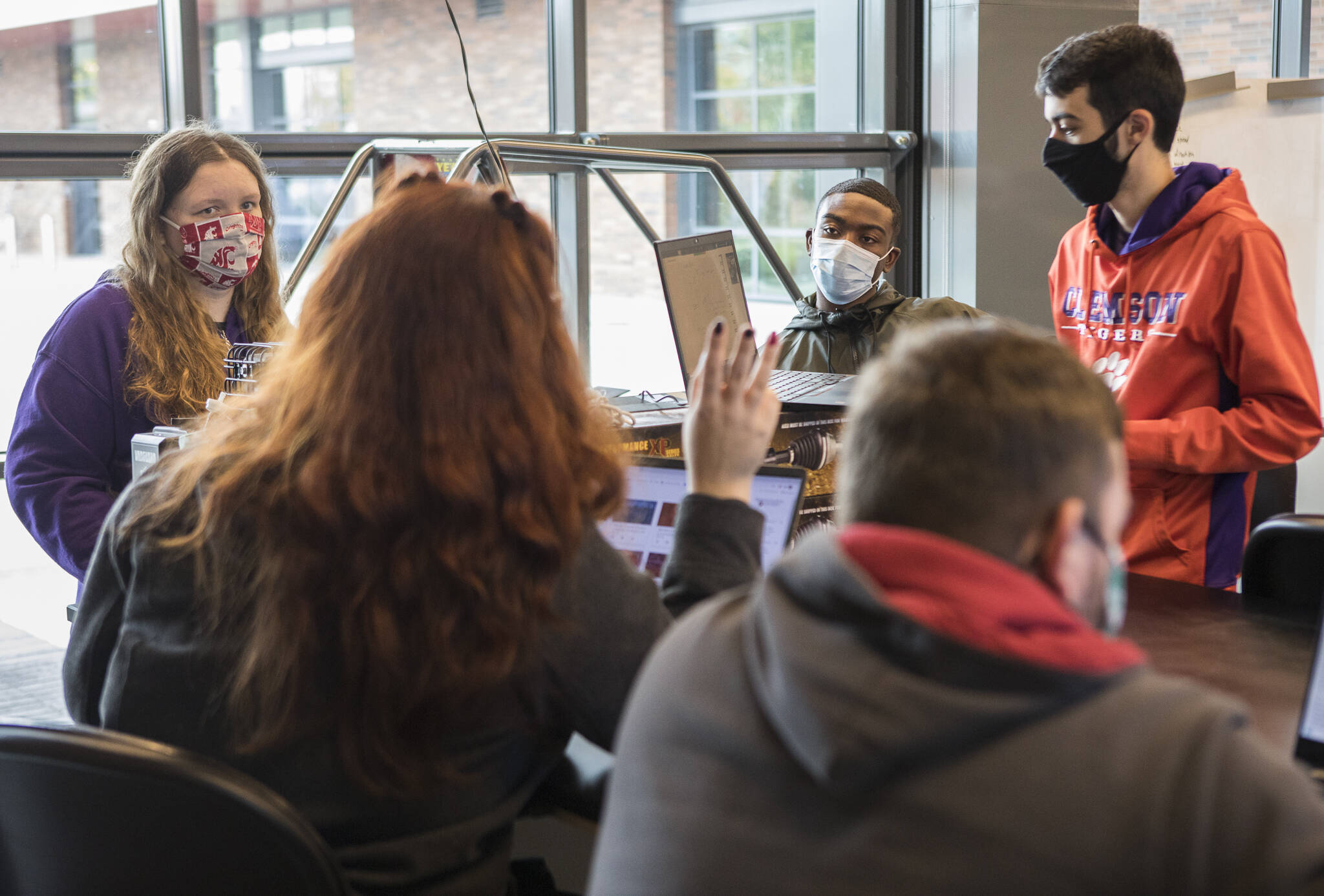 Washington State University and Clemson University students listen to Nichole Bascue, a WSU Everett student and team member, during a recent meeting in Everett. (Olivia Vanni / The Herald)