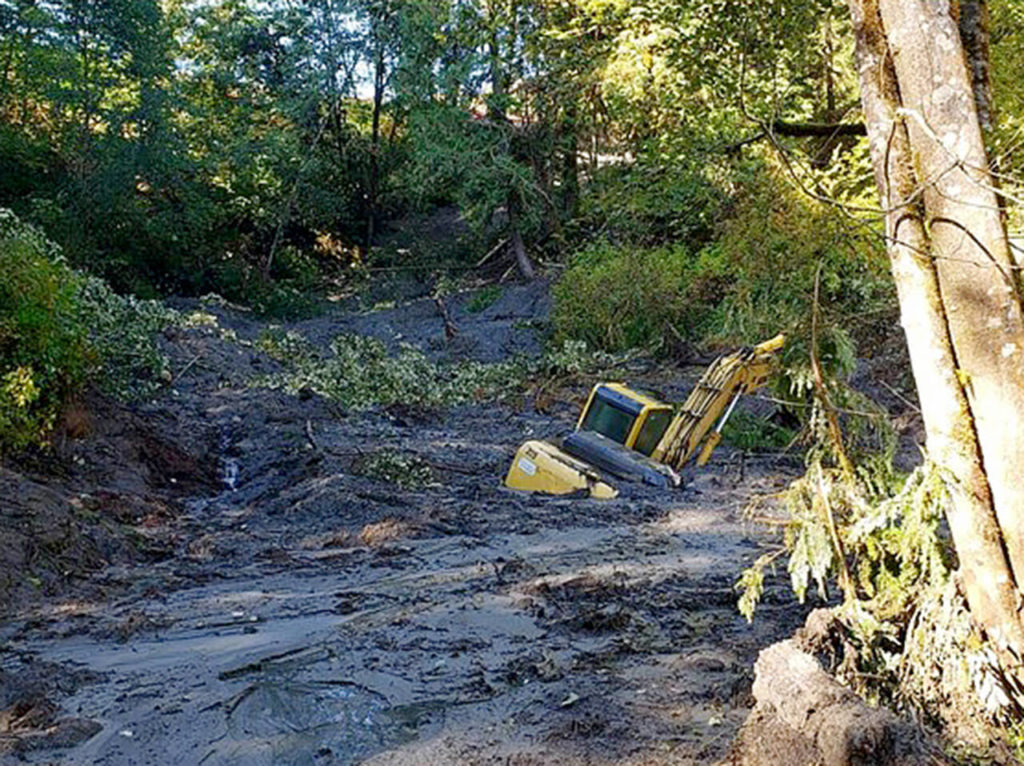 A buried excavator is seen in this view looking west toward the northeast corner of the landfill. (Washington State Department of Ecology/Olympic Pipe Line Co.)
