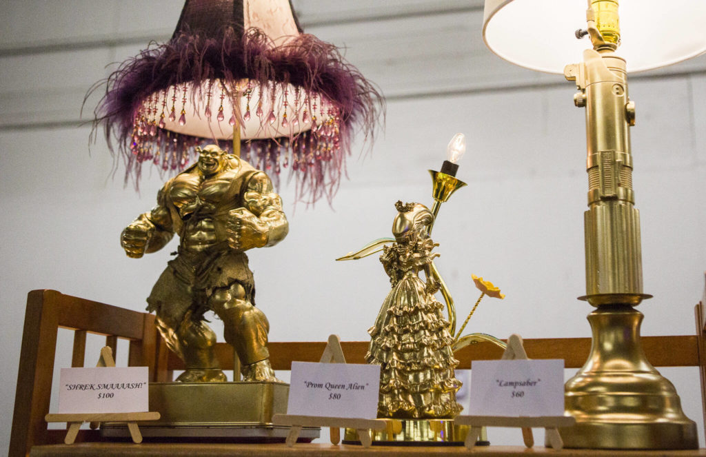 A gold Shrek, Alien and lightsaber lamp by Captain Slinky Weird Lamps at the last Oddmall Emporium of the Weird in 2019 in Monroe. (Olivia Vanni / Herald file)
