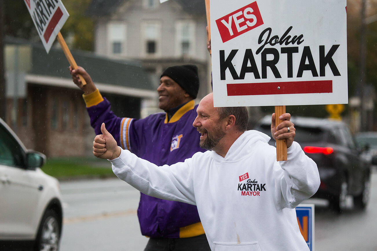 Snohomish Mayor John Kartak gives a thumbs up sign as he and supporters wave signs along 2nd Street on Monday, Nov. 1, 2021 in Snohomish, Washington.  (Andy Bronson / The Herald)