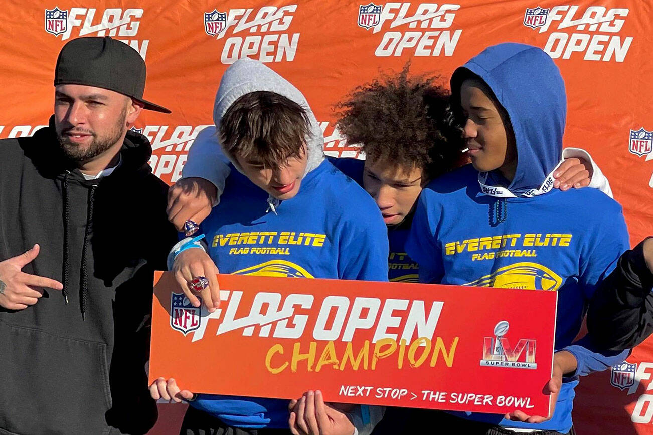 Members of the Everett Elite Flag Football 14-under team hold up a sign after winning the NFL FLAG open regional championship on Oct. 30, 2021, in Tacoma. (Photo provided by Jacob Hiatt)