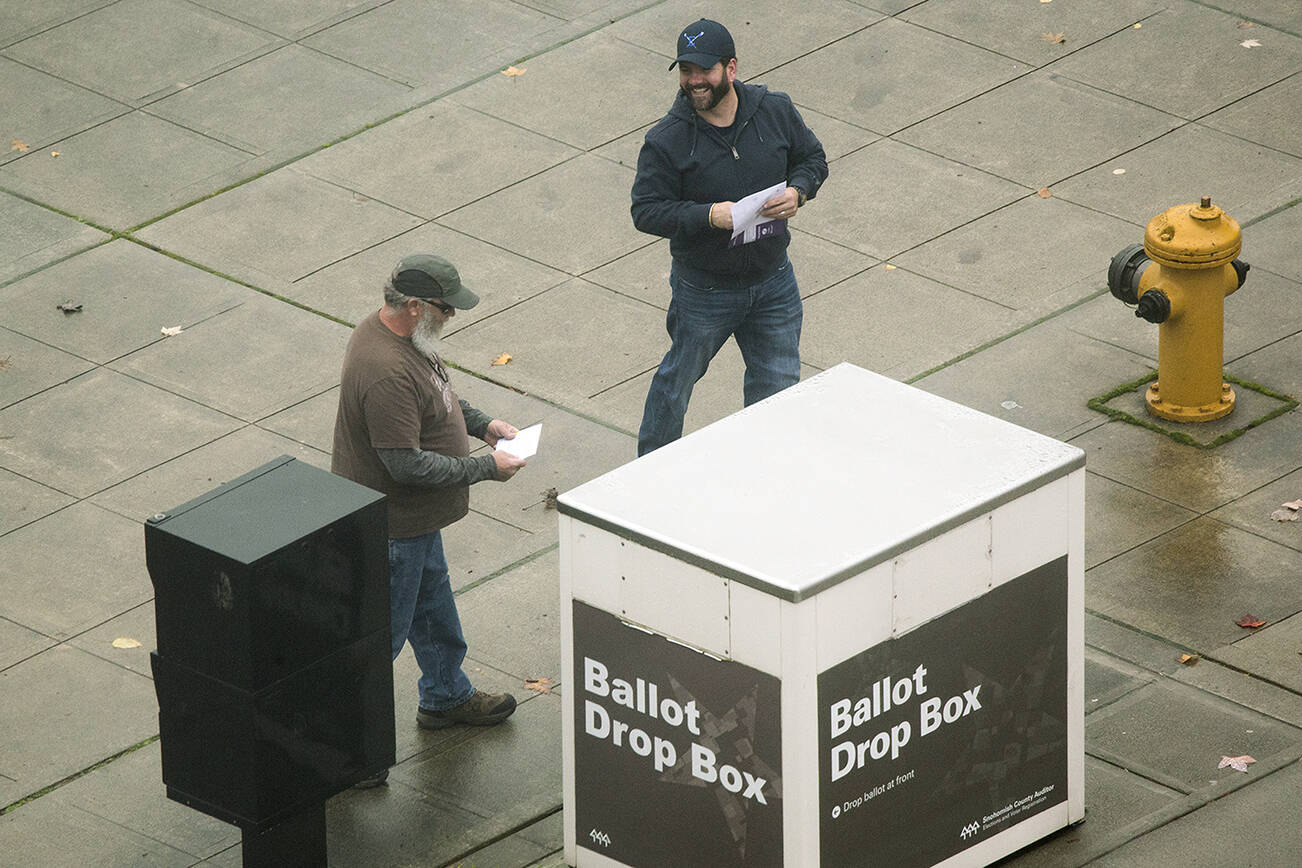 Two voters laugh as they drop off ballots at 3000 Rockefeller Avenue on Tuesday, Nov. 2, 2021 in Everett, Washington.  (Andy Bronson / The Herald)