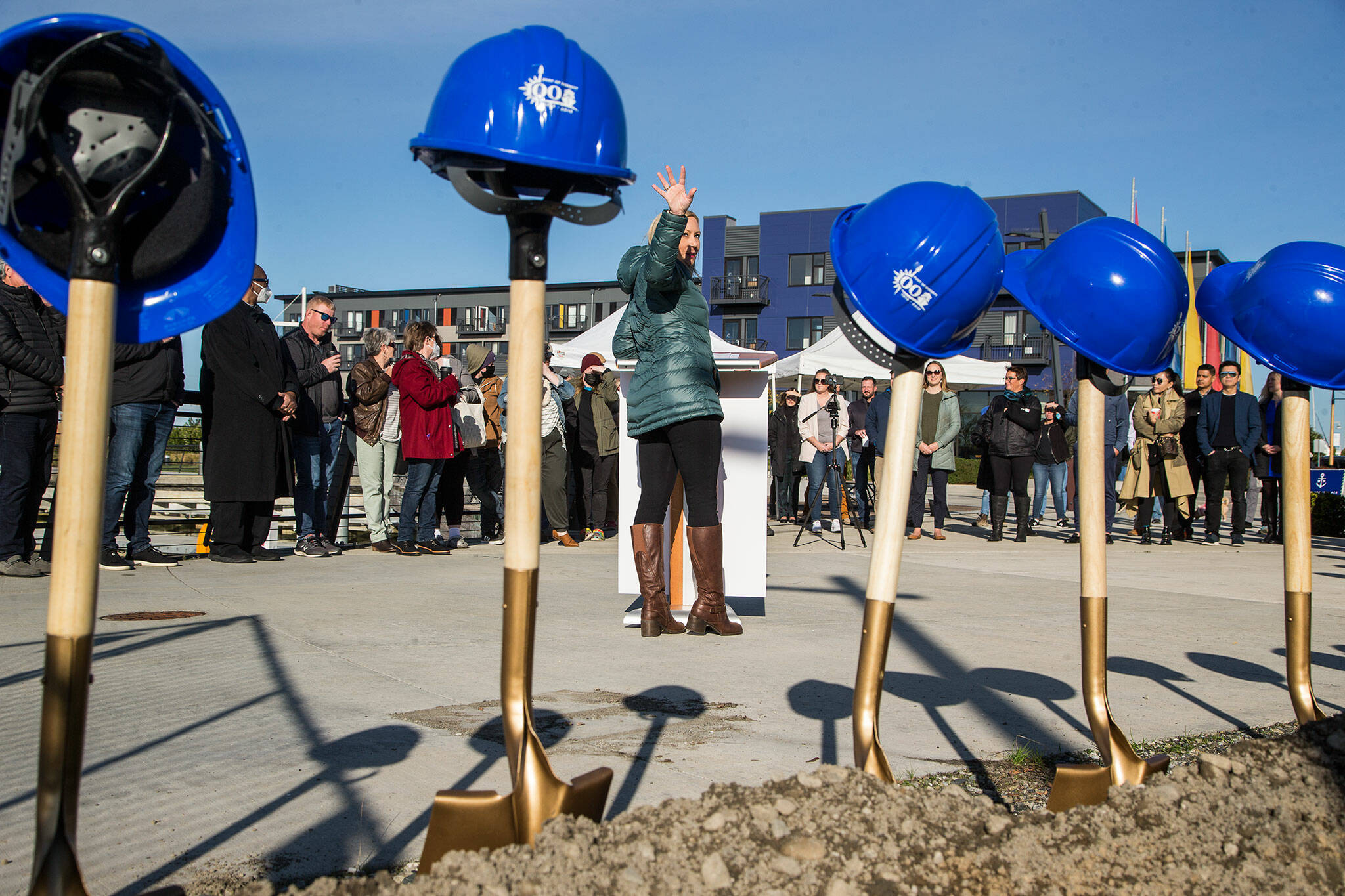 During a groundbreaking ceremony Monday, Port of Everett CEO Lisa Lefeber gestures toward the site of new food and retail establishments that will rise at Fisherman’s Harbor at Waterfront Place. (Andy Bronson / The Herald)