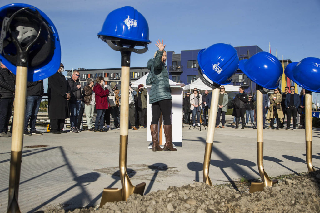 During a groundbreaking ceremony Monday, Port of Everett CEO Lisa Lefeber gestures toward the site of new food and retail establishments that will rise at Fisherman’s Harbor at Waterfront Place. (Andy Bronson / The Herald)
