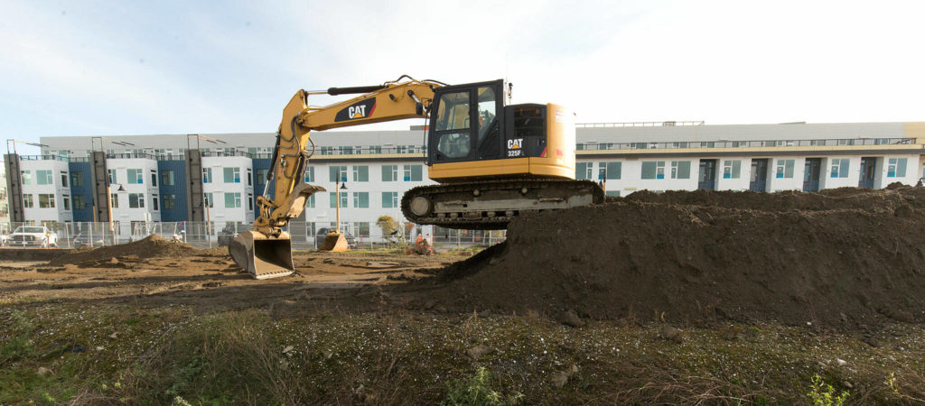 An excavator at work Monday at the site of new food and retail establishments at the Port of Everett. (Andy Bronson / The Herald)
