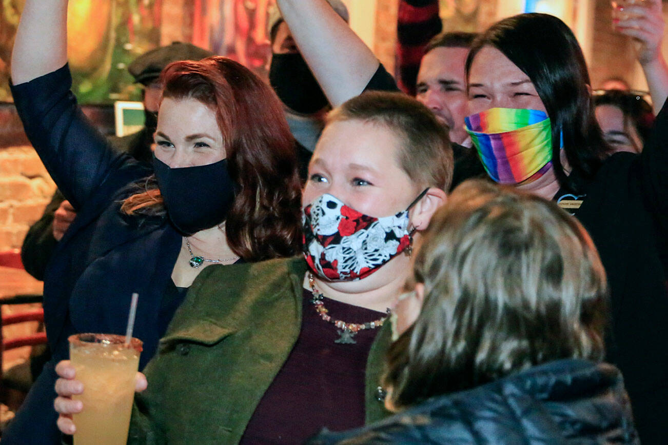 Mary Fosse, left to right, Liz Vogeli, and Paula Rhyne celebrate as election are read aloud Tuesday night at Black Lab Gallery in Everett on November 2, 2021. (Kevin Clark / The Herald)