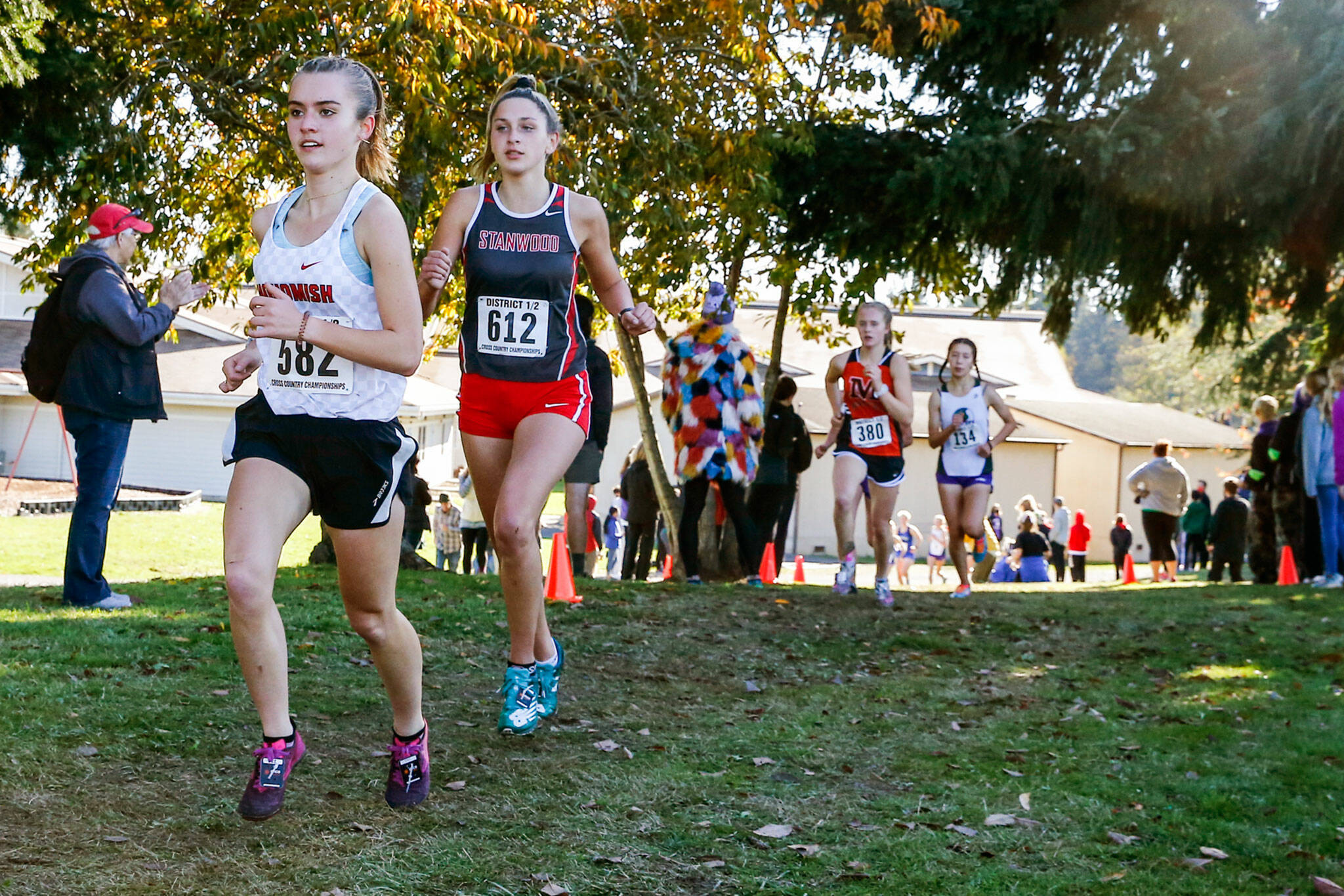 Snohomish sophomore Paige Gerrard (left) and Stanwood senior Leia Jones are among the top local runners to watch in Saturday’s state cross country championships. (Kevin Clark / The Herald)