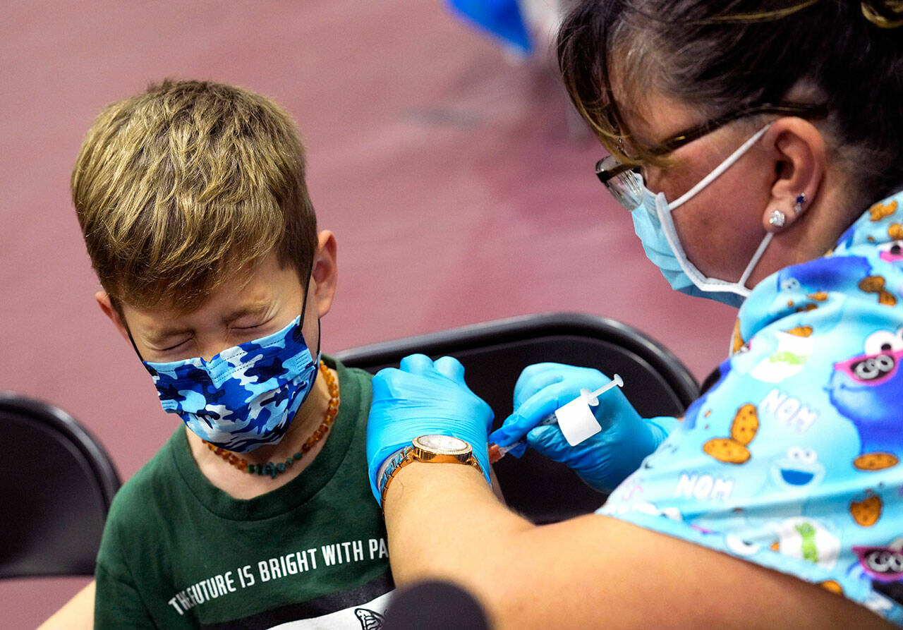 Wren Nagata, 7, of Pasadena, Calif., grimaces as he receives his covid-19 vaccine from Jacqueline Valdez during an event kicking off coronavirus vaccinations for children age 5-11 at Eugene A. Obregon Park in Los Angeles on Nov. 3 (Keith Birmingham / The Orange County Register via AP)