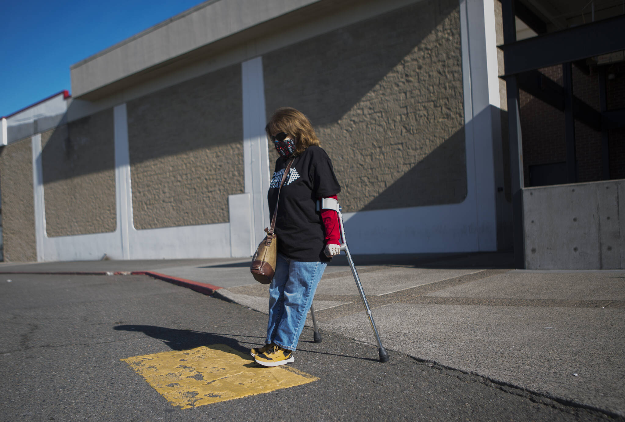 Leigh Spruce navigates a curb ramp March 11 at the Everett Mall. People with disabilities are calling attention to the infrastructure problems they face. (Olivia Vanni / Herald file)