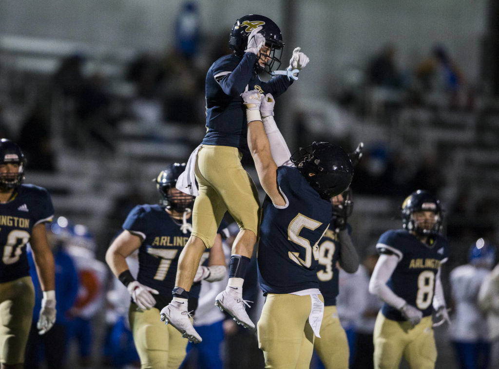 Arlington’s Nolan Welch lifts up Levi Younger in celebration of his touchdown during the game against Auburn Mountainview on Friday, Nov. 5, 2021 in Arlington, Wa. (Olivia Vanni / The Herald)
