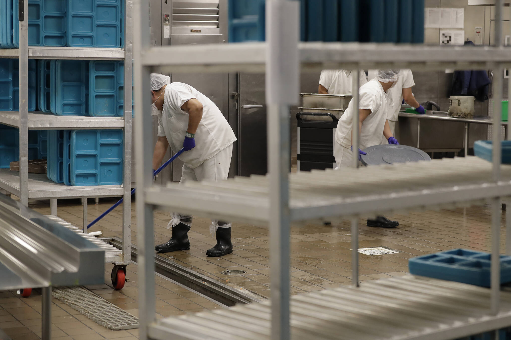 Workers are shown in the kitchen of The GEO Group’s immigration detention center in Tacoma during a media tour, Sept. 10, 2019. (AP Photo/Ted S. Warren, File)