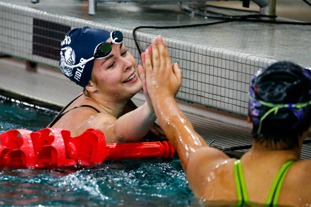 Glacier Peak’s Macy Fidler, left, celebrates with Kamiak’s Julia Lorenzo after the 100 yard backstroke during the 4A District Championships Saturday afternoon the at the Snohomish Aquatic Center on November 6, 2021. (Kevin Clark / The Herald)
