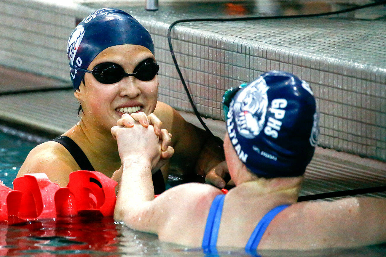 Glacier Peak's Lily Lao, left, and Alexa Sullivan celebrate a one two finish in the 200 yard freestyle Saturday afternoon during the 4A Girls District Championships at the Snohomish Aquatic Center on November 6, 2021. (Kevin Clark / The Herald)