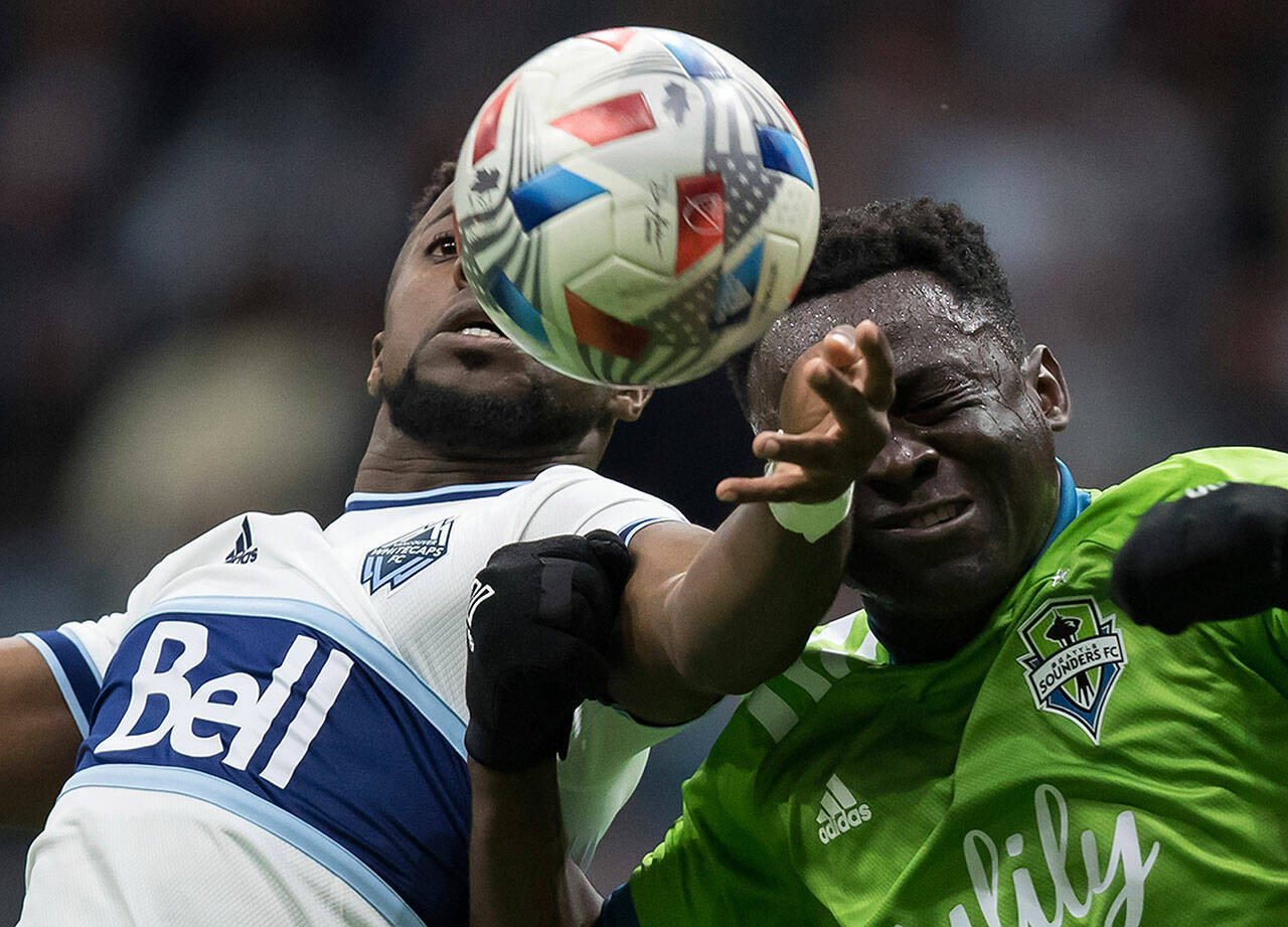 Vancouver Whitecaps’ Cristian Dajome, left, and Seattle Sounders’ Yeimar Gomez Andrade vie for the ball during the first half of a match in Vancouver, British Columbia on Sunday. (Darryl Dyck/The Canadian Press via AP)