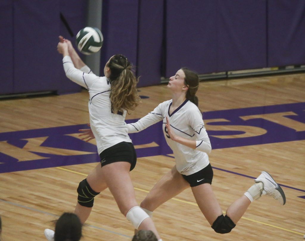 Lake Stevens’ Kylie Ascher sends the ball back into the court as she and teammate Anna Schroedl chase it down. (Andy Bronson / The Herald)
