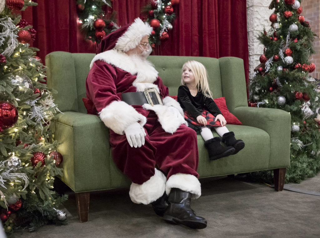 Dylan Blaney, 3, talks with Santa about what she wants for Christmas at the Santa Magic experience at Alderwood Mall on Friday in Lynnwood. (Olivia Vanni / The Herald)
