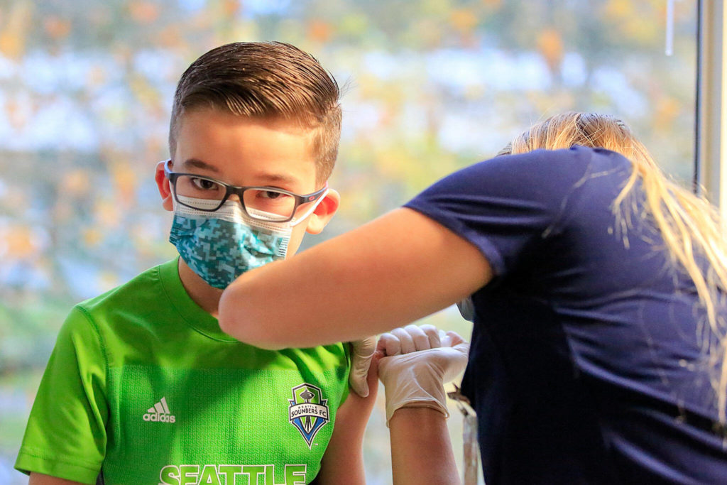 Kane Peterson, 9, gets a his COVID-19 vaccination Nov. 6 at North Sound Pediatrics in Mill Creek. (Kevin Clark / The Herald)
