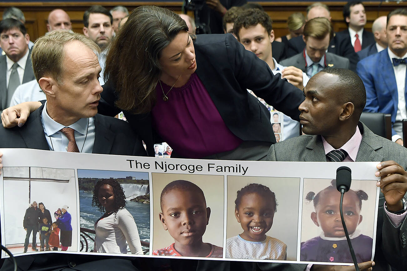 FILE - In this Wednesday, July 17, 2019, file photo, Rep. Angie Craig, D-Minn., center, talks with Paul Njoroge, right, who lost his wife and three young children, as Michael Stumo, left, who lost his daughter, looks on before the start of a House Transportation subcommittee hearing on aviation safety, on Capitol Hill in Washington. The year since the crash of an Ethiopian Airlines Boeing 737 Max has been a journey through grief, anger and determination for the families of those who died, as well as having far-reaching consequences for the aeronautics industry as it brought about the grounding of all Boeing 737 Max 8 and 9 jets, which remain out of service. (AP Photo/Susan Walsh, File)