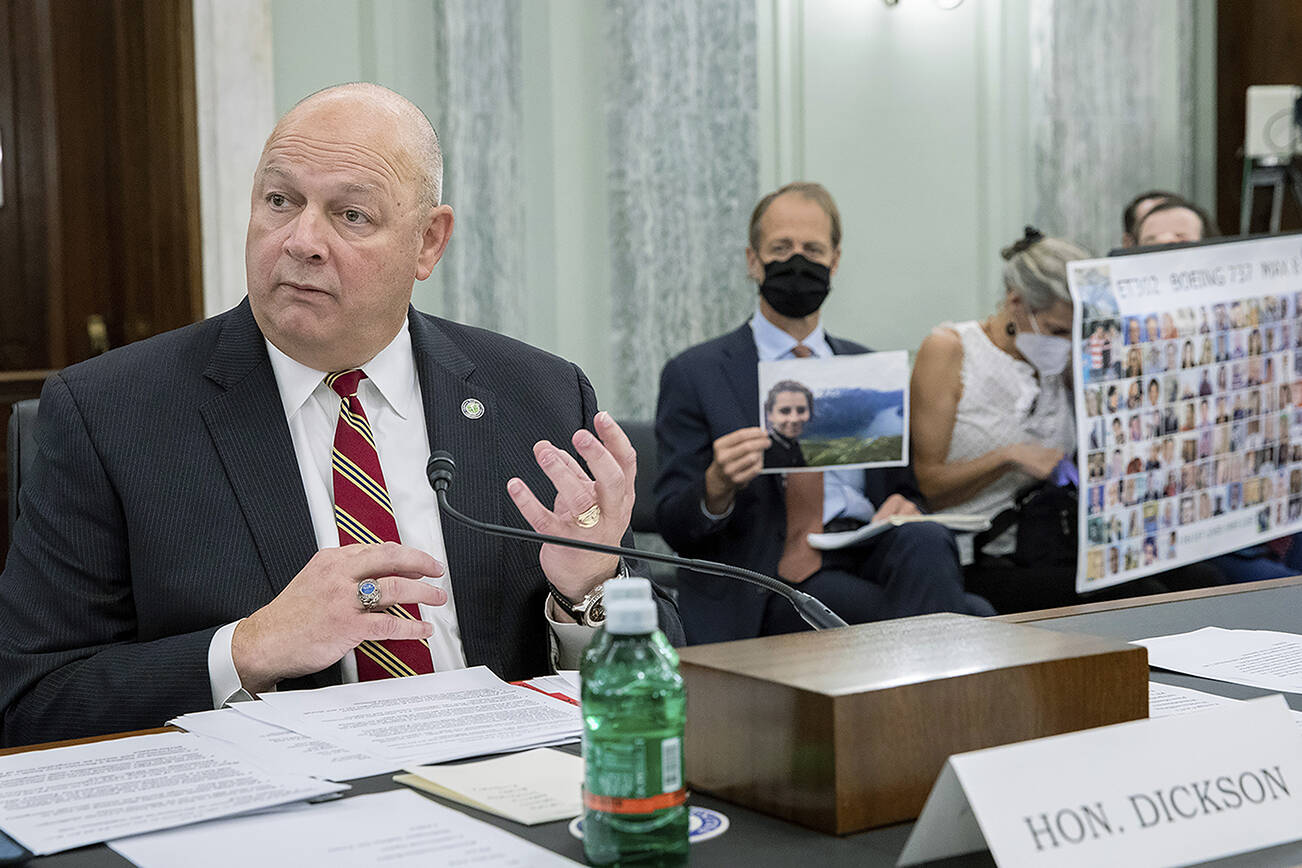 FAA Administrator Steve Dickson speaks to lawmakers as Michael Stumo, holding a photo of his daughter Samya Rose Stumo, and his wife Nadia Milleron, sit behind him during a Senate Committee on Commerce, Science, and Transportation hearing on the implementation of aviation safety reform at the US Capitol in Washington on Wednesday, Nov. 3, 2021. Samya Stumo was among those killed in a Boeing 737 Max 8 crash in 2019. (AP Photo/Amanda Andrade-Rhoades)