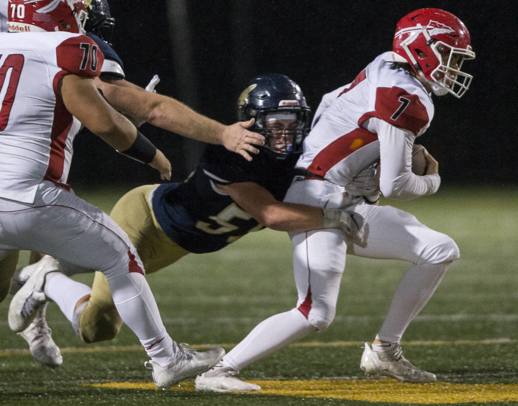 Arlington’s Josh Snow sacks Marysville-Pilchuck’s Jace Luton during the game on Friday, Oct. 15, 2021 in Arlington, Wa. (Olivia Vanni / The Herald)
