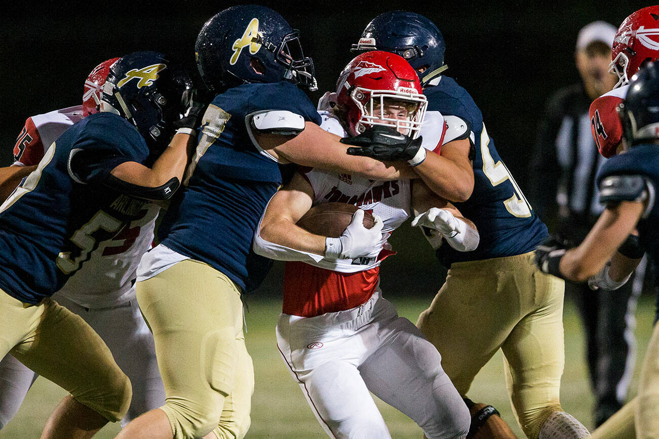 Marysville-Pilchuck's Dylan Carson is tackled by multiple Arlington players during the game on Friday, Oct. 15, 2021 in Arlington, Wa. (Olivia Vanni / The Herald)