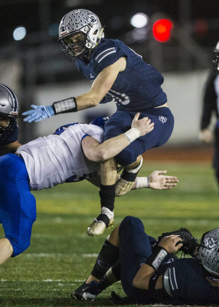Glacier Peak’s Ryan King jumps over a tackle while he runs the ball during the game against Bothell on Friday, Nov. 12, 2021 in Snohomish, Wa. (Olivia Vanni / The Herald)

