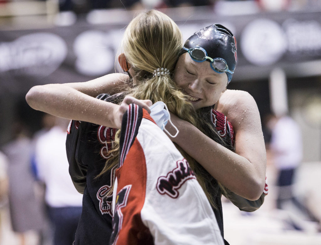 Snohomish sophomore Mary Clarke is congratulated after winning a Class 3A state title in the 50-yard freestyle during the girls swim and dive state championships Saturday in Federal Way. (Olivia Vanni / The Herald)
