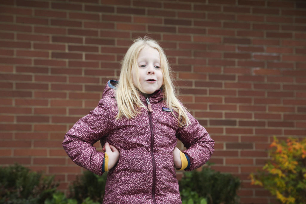 Ella, 6, flaps her arms like turkey wings as she answers questions about Thanksgiving outside Mount Pilchuck Elementary on Monday in Lake Stevens. (Andy Bronson / The Herald)
