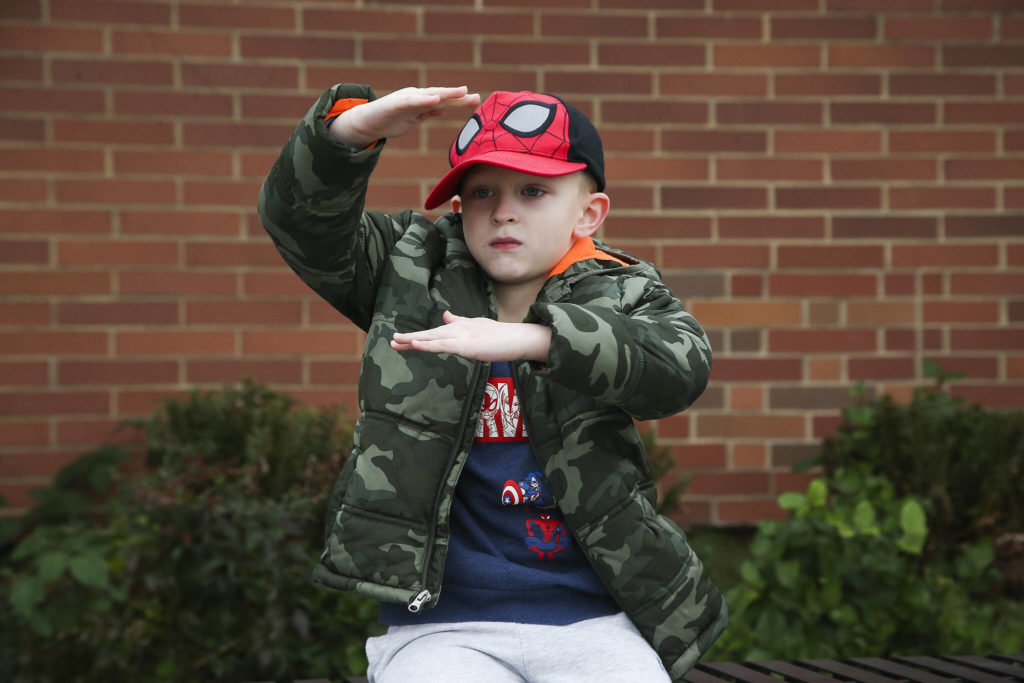 Ryan, 5½, shows off how tall pilgrims’ hats were as he answers questions about Thanksgiving outside Mount Pilchuck Elementary on Monday in Lake Stevens. (Andy Bronson / The Herald) 
