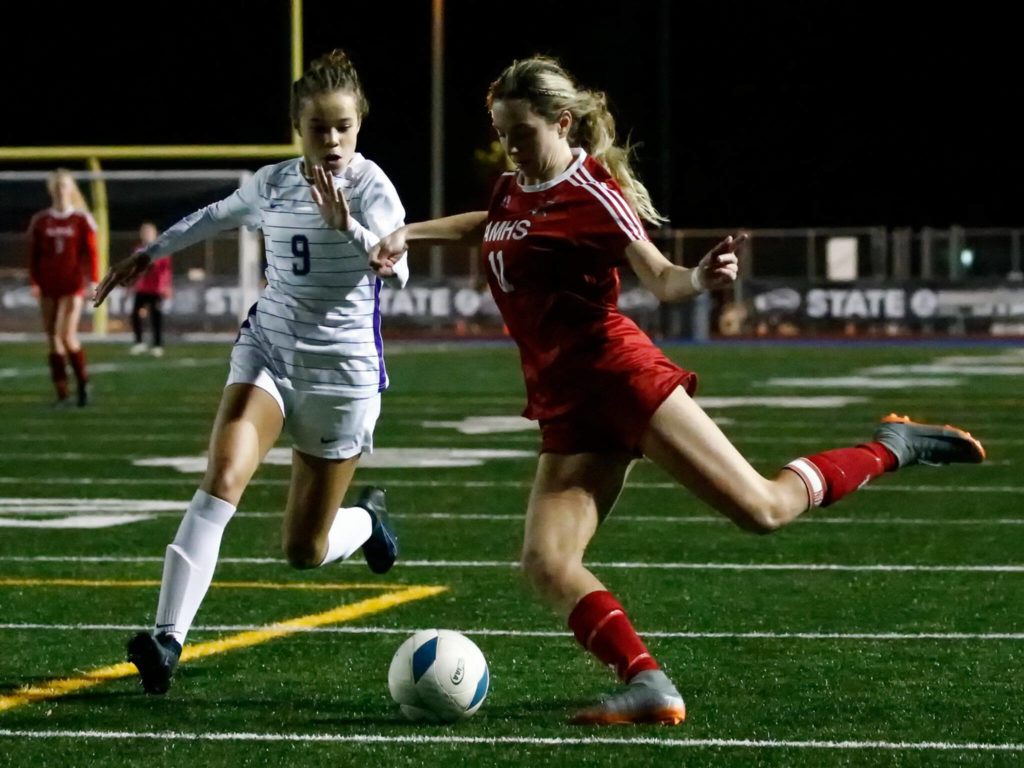 Archbishop Murphy’s Taylor Campbell takes a shot at goal with Columbia River’s Avah Eslinger defending Friday night at Shoreline Stadium on November 19, 2021. (Kevin Clark / The Herald)
