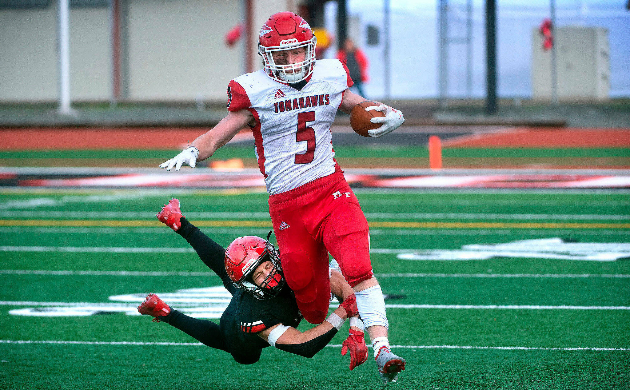 Marysville Pilchuck running back Dylan Carson slips through the tackle of Yelm defensive back Kyler Ronquillo during a 3A football state quarterfinal game on Saturday, Nov. 20, 2021, at Yelm High School. Marysville Pilchuck won the game 39-21. (Tony Overman / The Olympian)