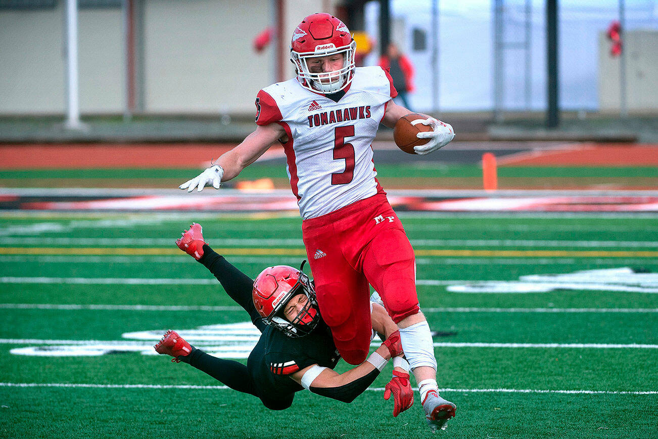 Marysville Pilchuck running back Dylan Carson slips through the tackle of Yelm defensive back Kyler Ronquillo during a 3A football state quarterfinal game on Saturday, Nov. 20, 2021, at Yelm High School. Marysville Pilchuck won the game 39-21. (Tony Overman / The Olympian)