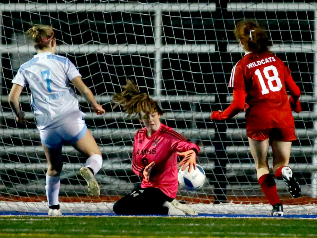 Archbishop Murphy’s Allie Williams stops a shot at goal by Hockinson’s Rayelle Stephens, left, with Archbishop Murphy’s Brie Cote Saturday evening during the 2A state championship at Shoreline Stadium on November 20, 2021. The Wildcats won 2-0. (Kevin Clark / The Herald)
