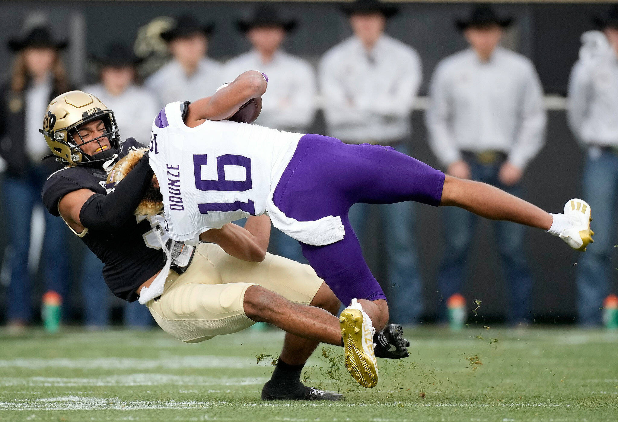 Colorado cornerback Christian Gonzalez (left) tackles Washington wide receiver Rome Odunze in the first half of a game Saturday in Boulder, Colo. (AP Photo/David Zalubowski)