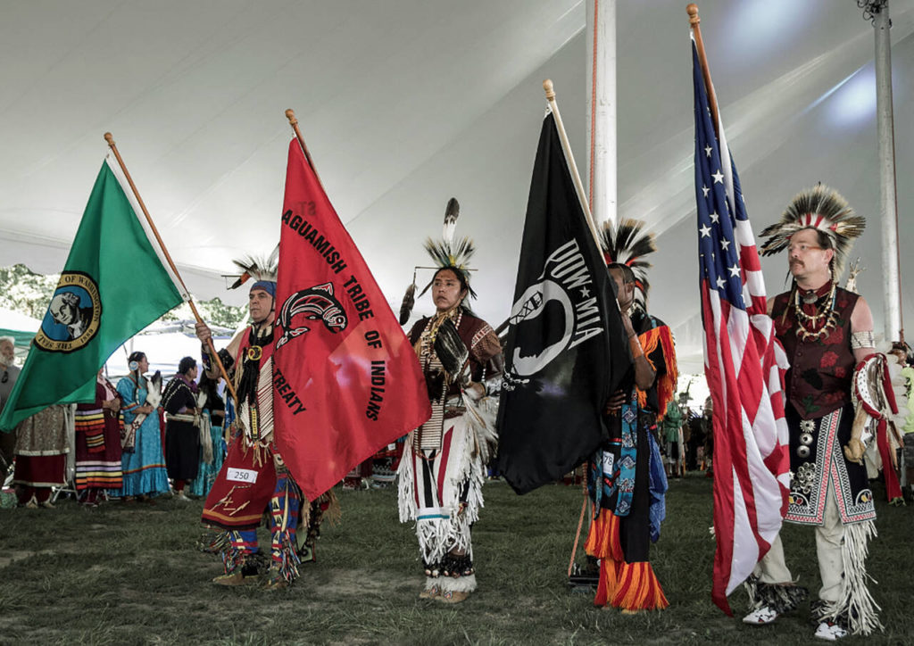 Stillaguamish tribal members hold flags during a powwow. (Contributed photo)
