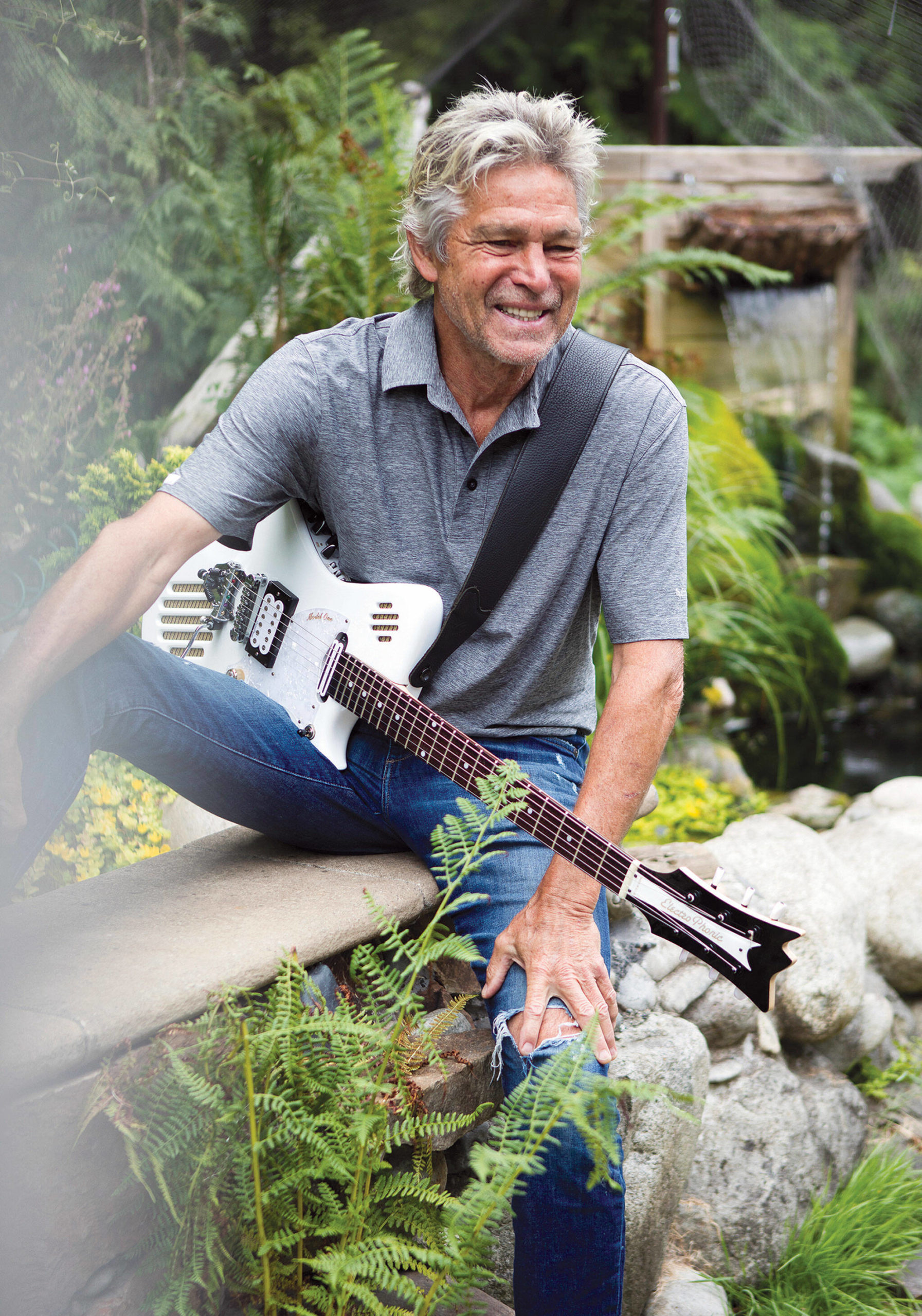 Roger Fisher pauses while jamming in the garden at his Monroe home. (Olivia Vanni / The Herald)