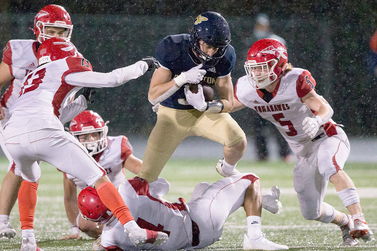 Arlington's Gage Price leaps over a Marysville-Pilchuck player during the game on Friday, Oct. 15, 2021 in Arlington, Wa. (Olivia Vanni / The Herald)