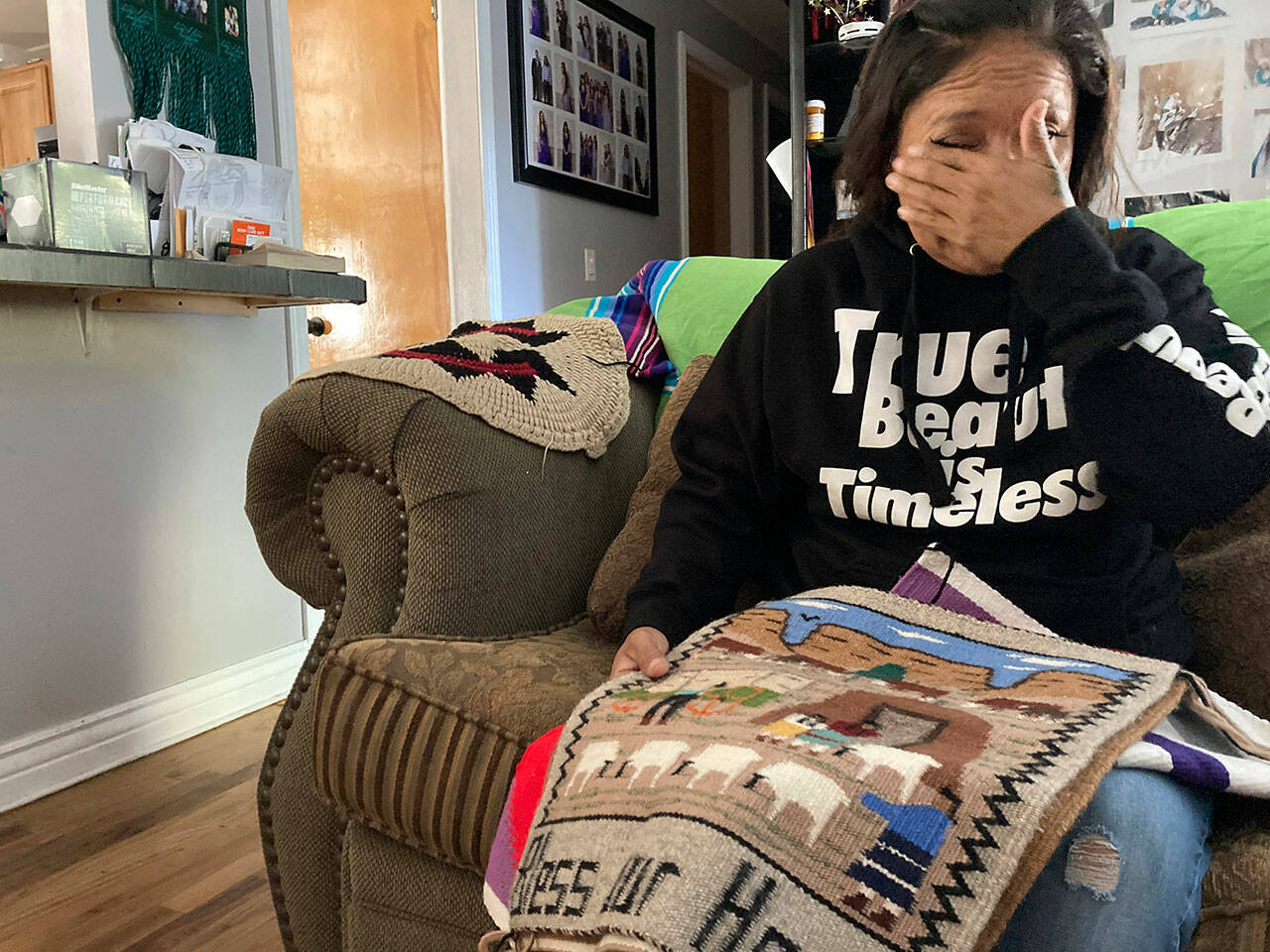 Seraphine Warren cries as she talks about her missing aunt, Navajo rug weaver Ella Mae Begay, while holding a rug made by Begay at her home in Tooele, Utah, on Sept. 23. Begay, 62, disappeared in June, one of thousands of missing Indigenous women across the U.S. The extensive coverage of the Gabby Petito case renewed calls to also shine a spotlight on missing people of color. (Lindsay Whitehurst / Associated Press)