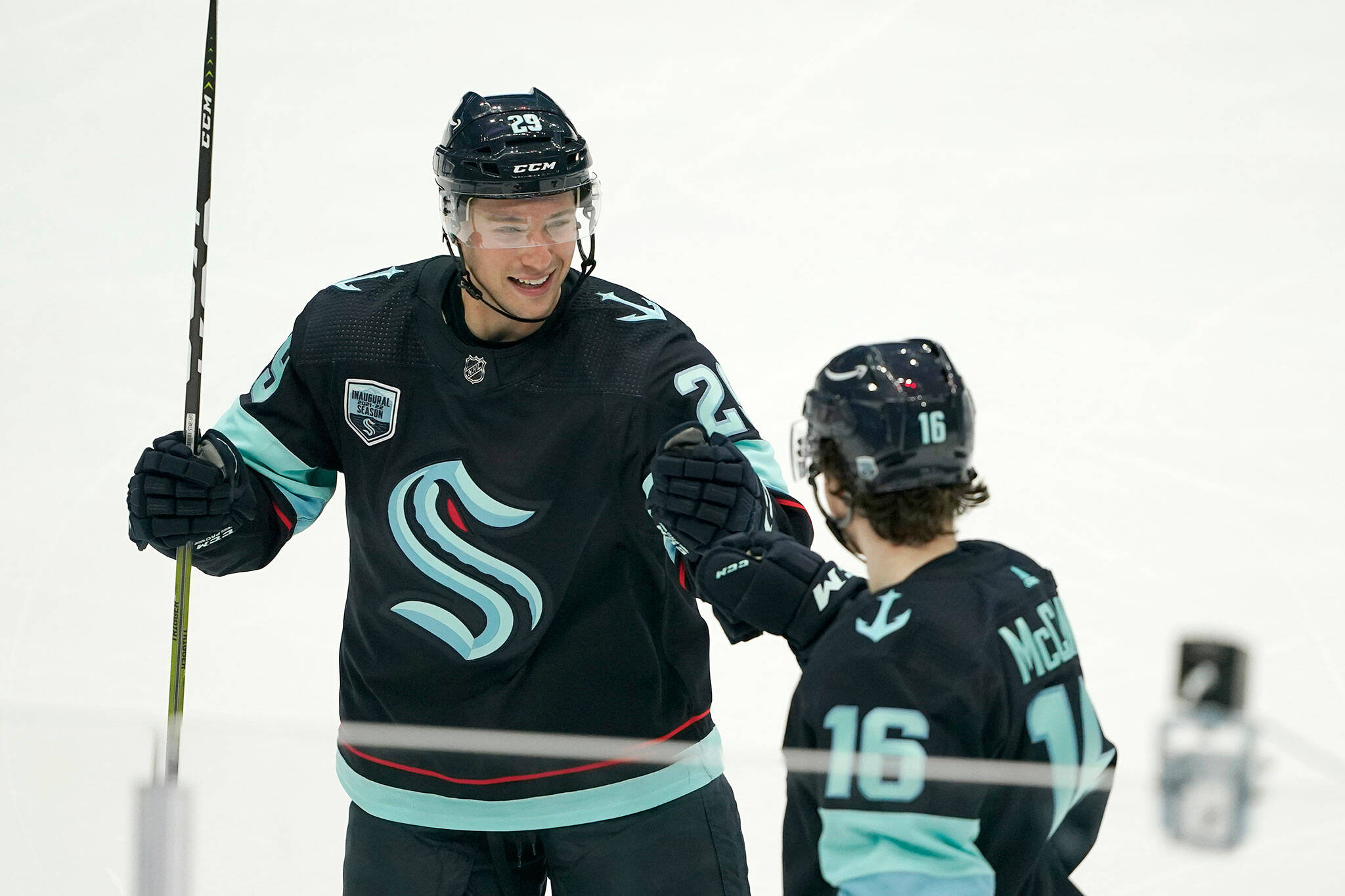 Kraken defenseman Vince Dunn (left) greets center Jared McCann after McCann scored a goal against the Hurricanes with an assist from Dunn during the second period of a game Wednesday in Seattle. (AP Photo/Ted S. Warren)