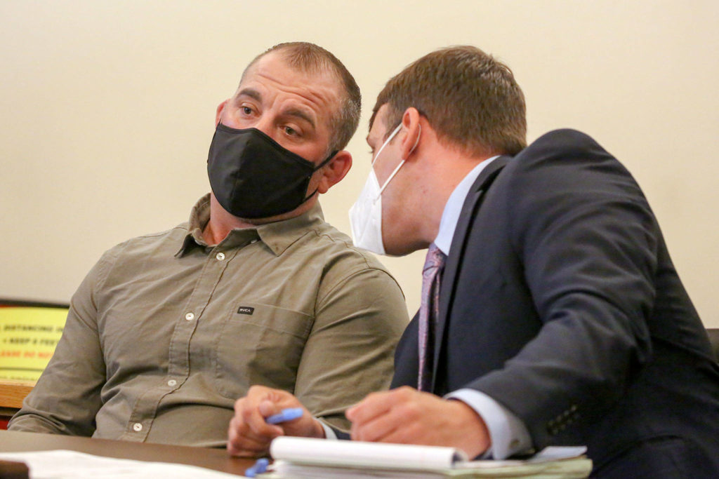 Jeremy Pidgeon (left) confers with his defense attorney John Garza during his sentencing at Snohomish County District Court in Monroe on June 23. (Kevin Clark / The Herald)
