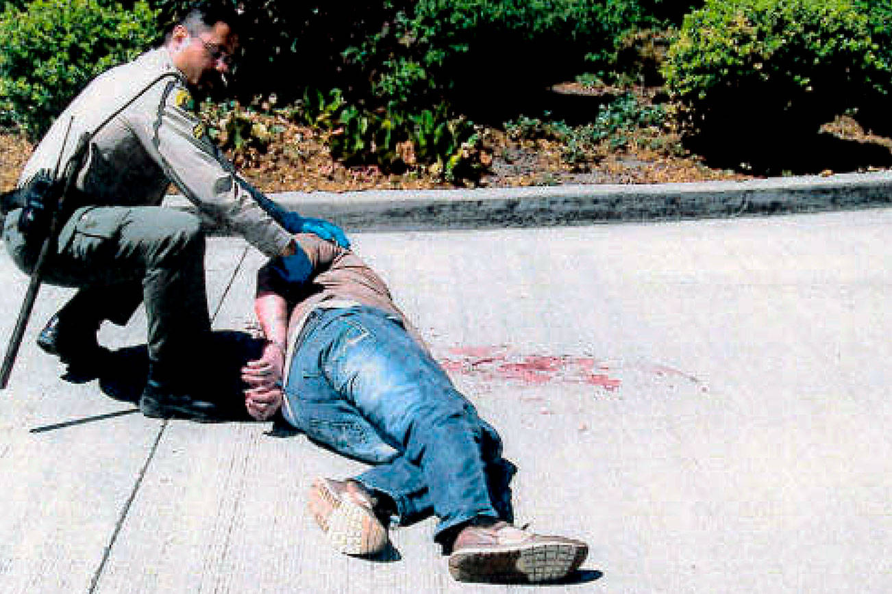 Robert Preston in 2014 on the ground at an Everett park-and-ride, where he said he was assaulted by a Snohomish County sheriff's deputy. The incident led to a lawsuit and a $150,000 settlement. (Snohomish County Sheriff's Office via federal court filing) 20210822