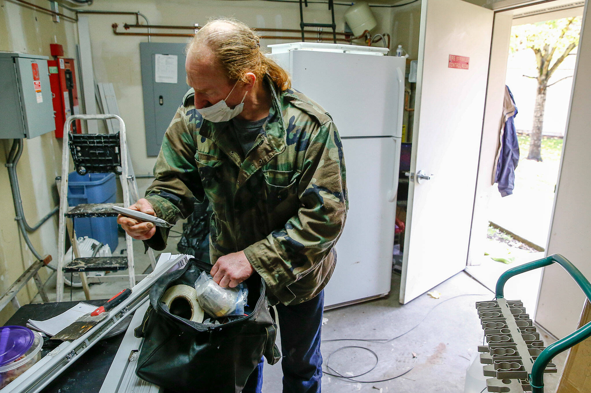 Dennis Willard gathers his tools for his next repair in Monroe on Oct. 29. (Kevin Clark / The Herald)