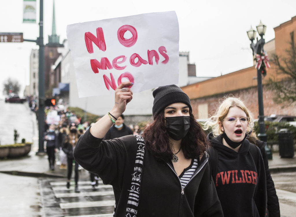 Students hold signs and chant as they walk down Rockefeller Avenue during a walkout from Everett High School on Dec. 16. (Olivia Vanni / The Herald)
