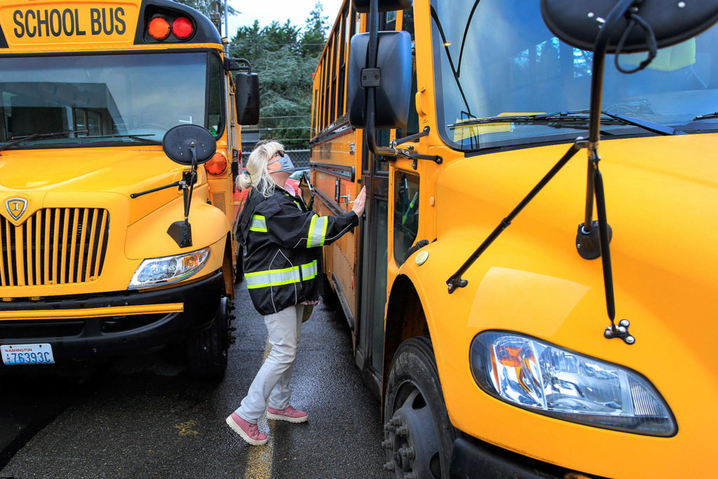 Kelly Brookbank, a former resident of Whispering Pines, performs a pre-drive check on a school bus in Seattle. (Kevin Clark / The Herald)
