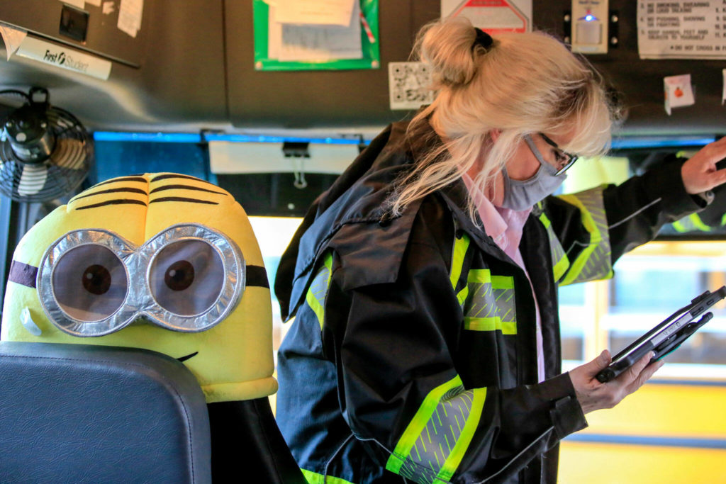 Kelly Brookbank, a former resident of Whispering Pines, performs a pre-drive check on a school bus in Seattle. (Kevin Clark / The Herald)
