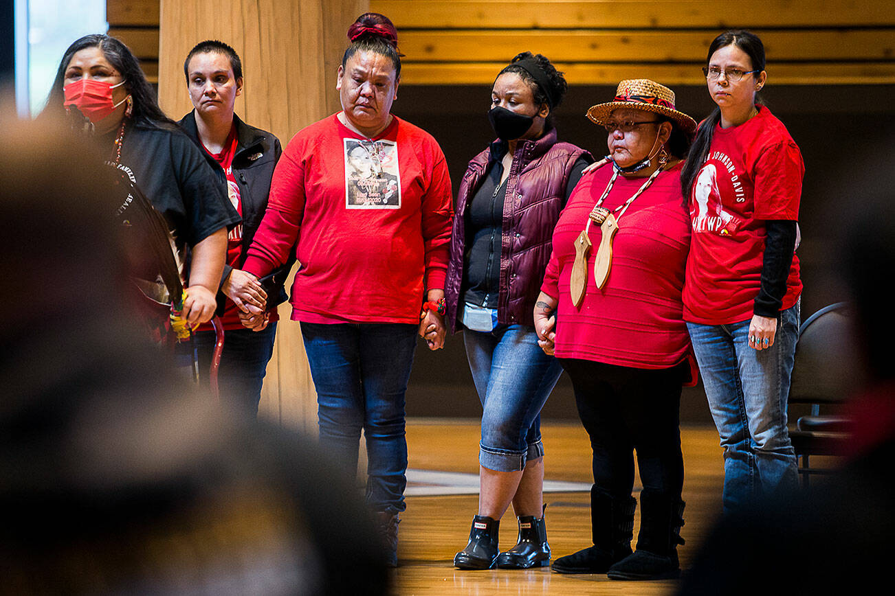 The family of Mary Ellen Johnson-Davis stand together holding hands while Roxanne White speaks during a gathering to support the continued search for Mary Ellen on Thursday, Dec. 9, 2021 in Tulalip, Wa. (Olivia Vanni / The Herald)