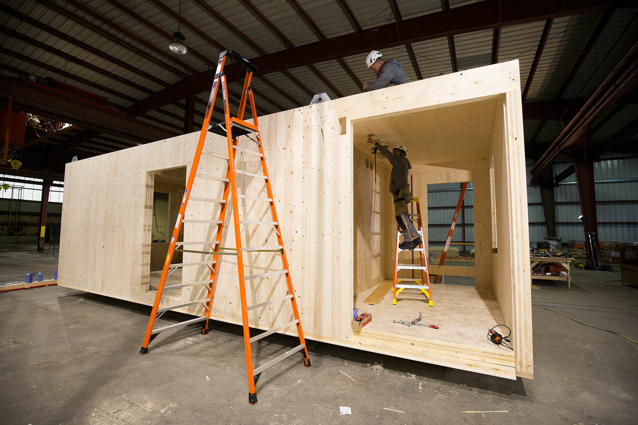 Carpenters from Switzerland build the first modular home made from cross-laminated timber inside a warehouse on Marine View Drive in Everett. (Andy Bronson / The Herald)